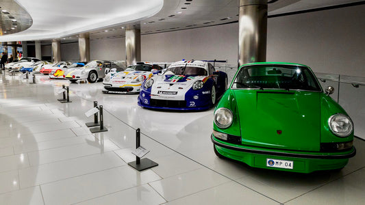 A group of various Porsche models in a gallery